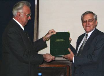 Prof Cristian Hera President of the Romanian Academy for Agricultural and Forestry Scinces (left) presenting the prestigious "Academic Merit" Award to Dr James, Chair and Founder of ISAAA 